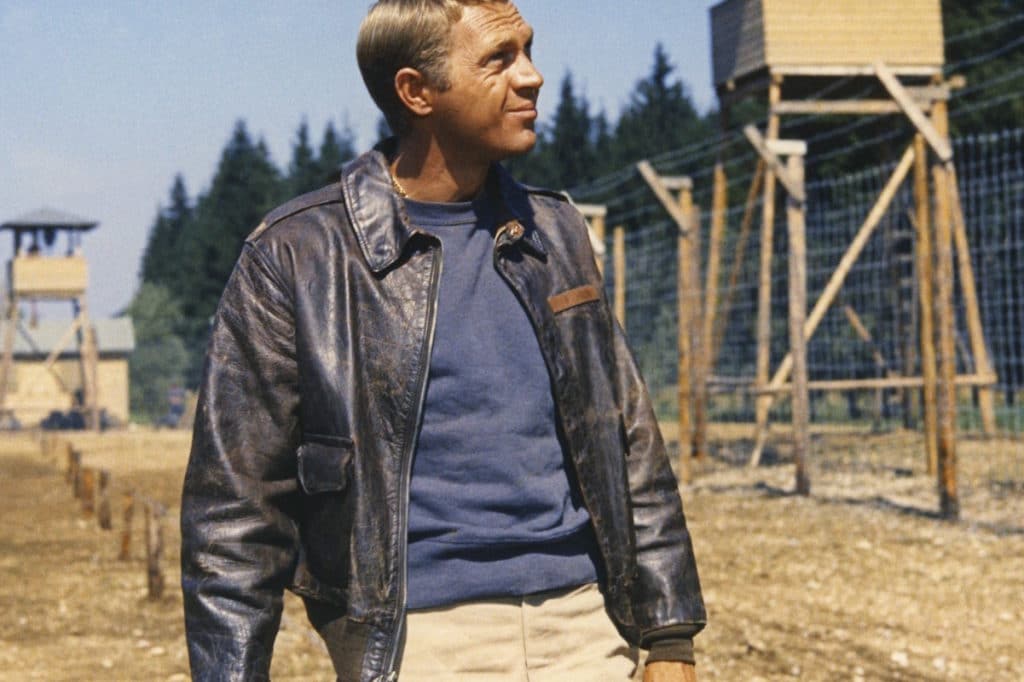 Steve McQueen wearing a leather motorcycle jacket.