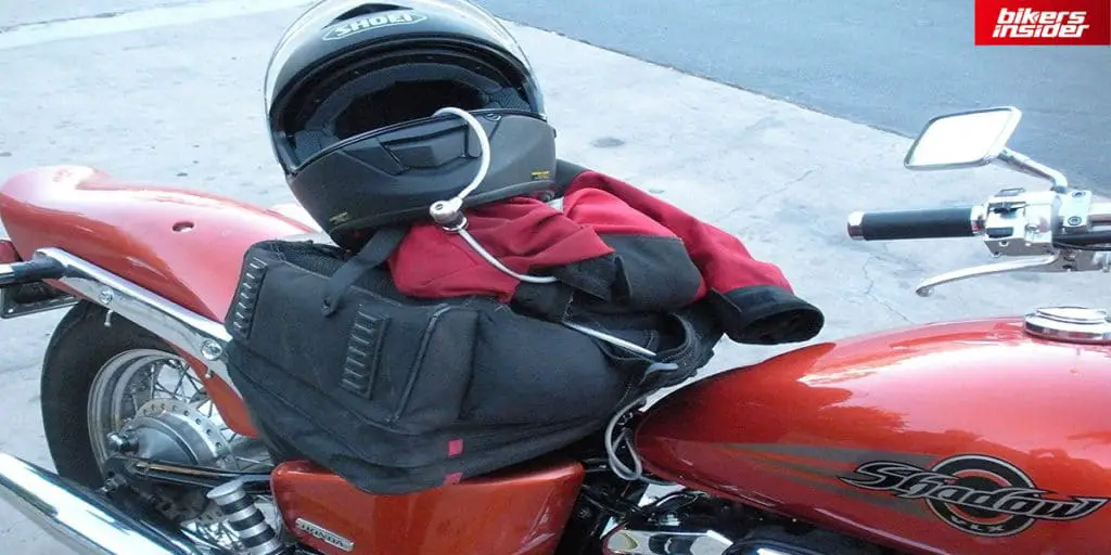 Cord lock lock wraps around the motorcycle helmet and another motorcycle part to securely lock the helmet.